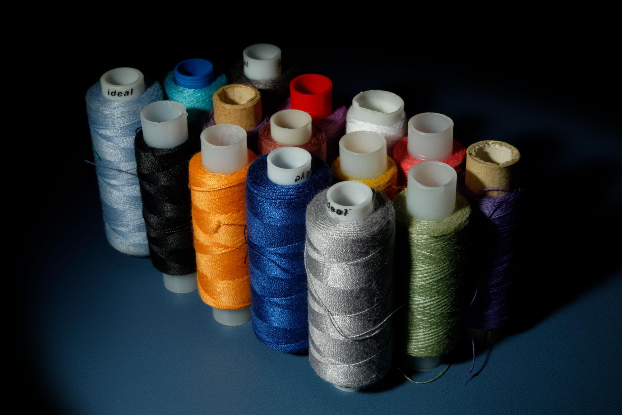 stack of thread spools and precision needles